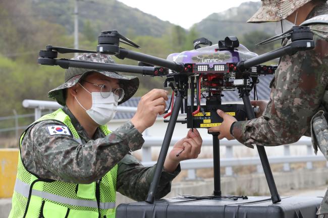 육군과학화전투훈련단(KCTC)이 과학기술 발전 및 안보환경 변화에 발맞춰 차세대 과학화전투훈련체계 구축에 나섰다. 사진은 KCTC 요원들이 새롭게 도입 중인 ‘드론마일즈’ 장비를 드론에 장착하는 모습. 조종원 기자