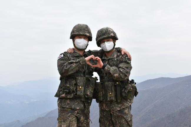 육군12사단 향로봉대대에서 복무 중인 문승환(왼쪽) 상병, 문대환 일병이 서로를 격려하며 손 하트를 그려 보이고 있다. 사진 제공=김은택 중위