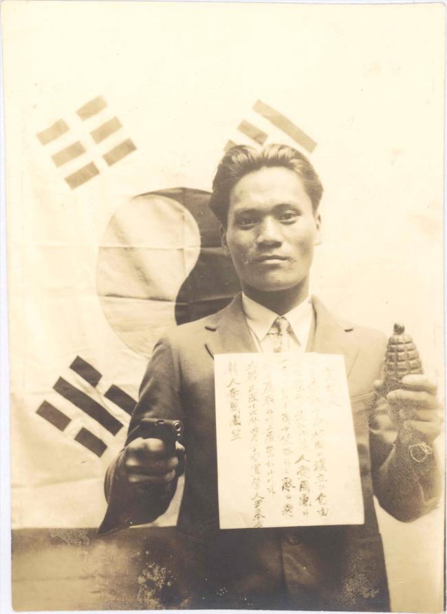 왼손에 폭탄, 오른손에 권총을 들고 태극기 앞에서 절명사를 가슴에 붙이고 사진을 찍은 윤봉길 의사.