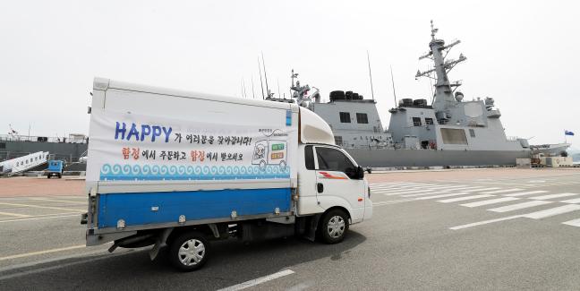 해군군수사령부 보급창의 1.5톤 트럭이 진해 군항기지 내에 정박해 있는 함정으로 피복을 배송하는 ‘해피(Happy) 오더·배달 서비스’를 하고 있다. 