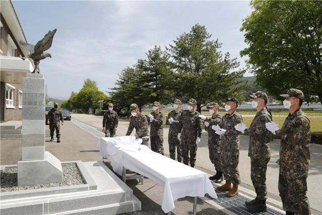 육군3군단 항공단 관계자들이 3만 시간 무사고비행 달성 기념비 앞에서 박수로 대기록 달성을 자축하고 있다.  부대 제공 