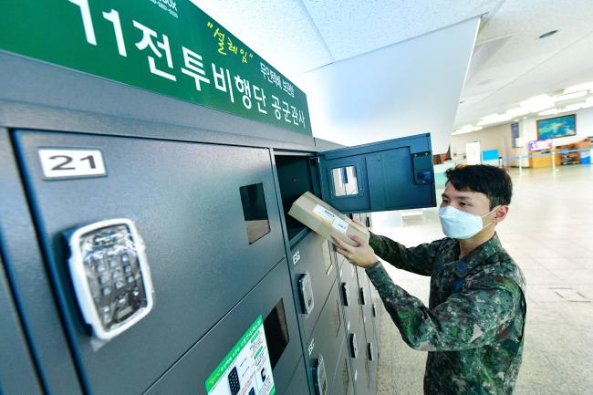 공군11전투비행단 장병이 부대 면회실에 설치된 무인 택배 보관함을 이용하고 있다.  사진 제공=편보현 원사