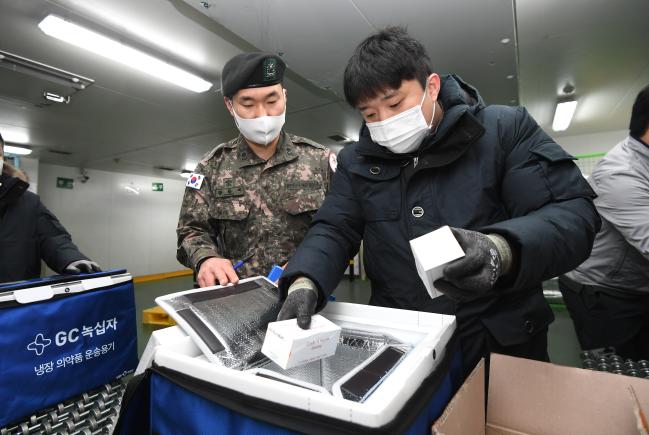 12일 오전 충북 오창 물류창고에서 코로나19 백신수송지원본부 주관으로 열린 ‘모더나 백신 수송 모의훈련’ 중 군 감독관과 민간업체 담당자가 모의 백신을 지역 거점창고로 수송하기 위해 냉장용 이동 상자에 소분하고 있다.  조용학 기자