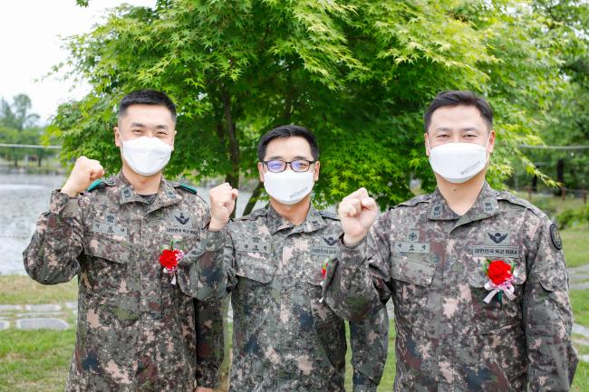 과거 공부하고 훈련받았던 육군3사관학교에서 교수, 교관, 훈육관으로 각각 임무 수행 중인 이준석·강구한·이진학 소령(오른쪽부터)이 후배이자 제자인 생도들이 선물한 카네이션을 가슴에 꽂고 기념사진을 찍고 있다.  부대 제공