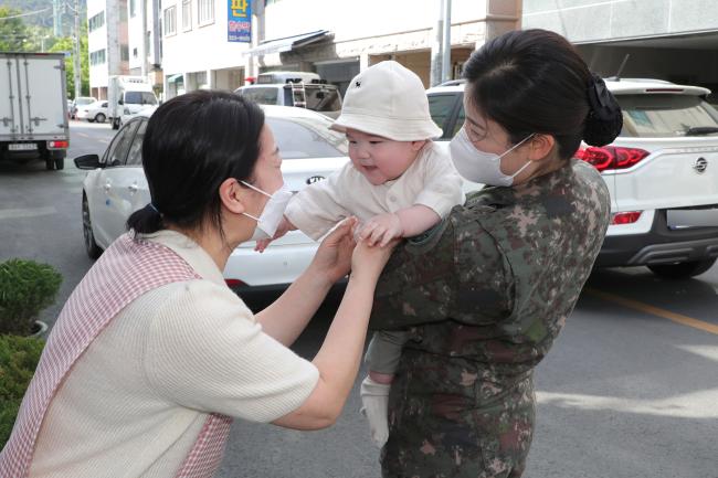 육군50사단 전소민(중사·오른쪽) 회계복지기금담당관이 출근 전 대구 아이들세상 어린이집 김인숙(왼쪽) 원장에게 아들 이윤건 군을 맡기고 있다. 전 중사는 육아시간 제도를 이용해 아들의 어린이집 등원을 돕고 있다.
