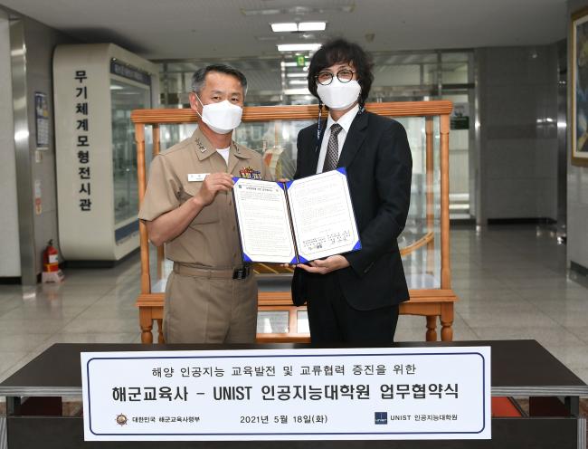 해군교육사령부와 울산과학기술원(UNIST) 인공지능대학원이 18일 업무협약식을 진행한 가운데 강동훈(왼쪽) 사령관과 노삼혁 인공지능대학원장이 협약서를 들어보이고 있다.  사진 제공=서준혁 중사