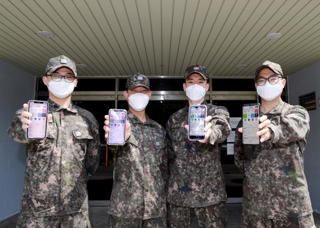 해군1함대사령부 군사경찰대대 서대근·김태민 병장, 남영현·손준혁 상병(왼쪽부터)이 군 복무 중 자기계발에 큰 도움이 된 자신의 휴대전화를 내보이고 있다.                  사진 제공=조웅노 중사 