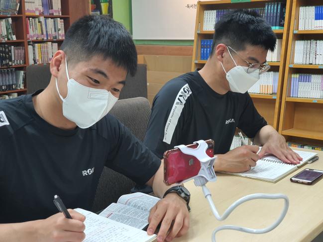 육군28사단 양명철(왼쪽) 병장이 일과 후 휴대전화를 활용해 전공 공부를 하고 있다.
  부대 제공