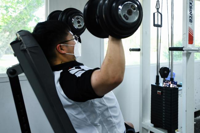 공군3방공유도탄여단 기지대 류제룡 상병이 휴대전화로 효율적인 헬스기구 이용법 영상을 보며 운동하고 있다.  사진 제공=한승호 일병