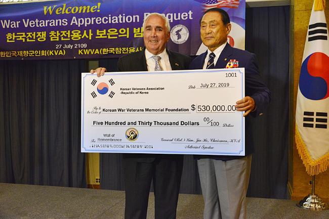 김진호(오른쪽) 향군회장이 지난 2019년 미국 워싱턴에서 개최된 ‘한국전쟁 참전용사 보은의 밤’ 행사에서 한국전참전용사추모재단 존 틸럴리 이사장에게 향군 ‘추모의 벽’ 성금을 전달하고 있다.  향군 제공
