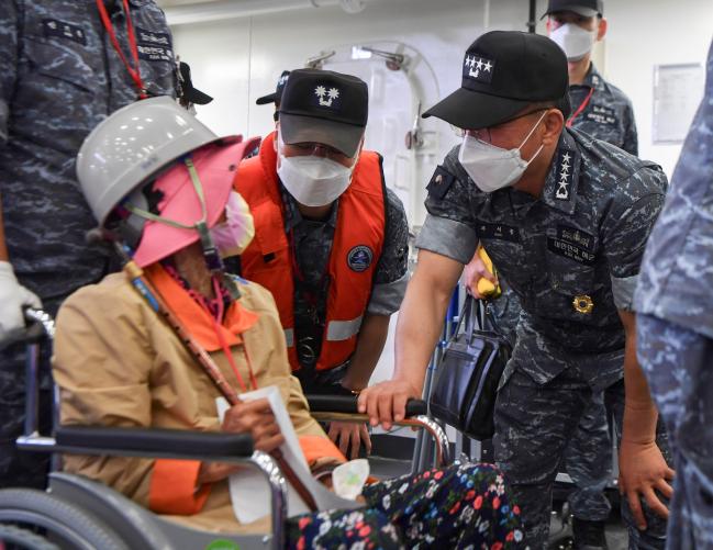 부석종(오른쪽) 해군참모총장이 17일 도서지역 주민 해상 접종이 이뤄지고 있는 한산도함을 방문해 해군 방역 책임관으로서 코로나19 백신 접종 현장을 점검하고 접종을 마친 주민들의 건강 상태를 살피고 있다.  해군 제공