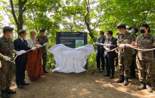 김정수(중장·왼쪽 넷째) 육군사관학교장, 이홍기(오른쪽 셋째) 육사총동창회장 등 참석자들이 22일 경기도 남양주 불암산 중턱에 있는 ‘불암산 호랑이 유격대’ 제2동굴 앞에서 열린 안내 간판 제막식에서 간판을 덮은 천을 걷고 있다. 