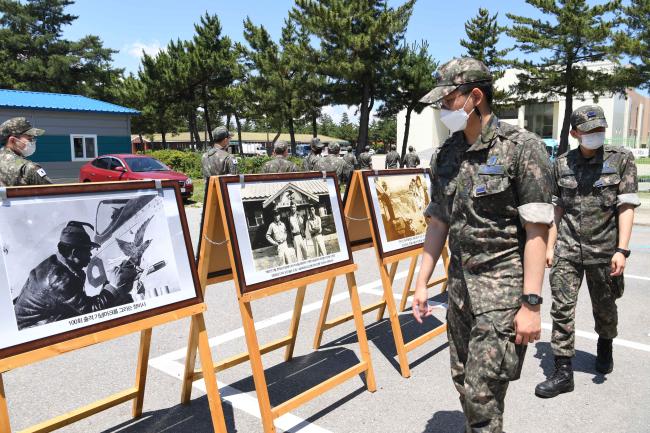 공군18전투비행단 장병들이 호국 안보 주간에 진행된 6·25 상기 부대 역사 사진전에 전시된 사진들을 관람하고 있다.  사진 제공=박의찬 하사