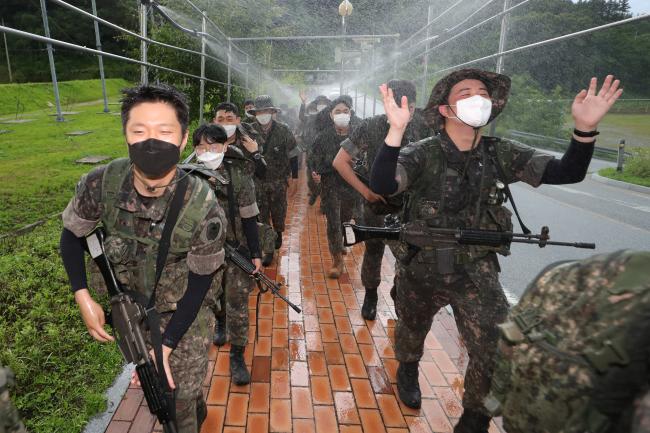 훈련을 마친 학군사관 후보생들이 찬물이 뿜어져 나오는 샤워터널을 지나며 무더위를 식히고 있다.