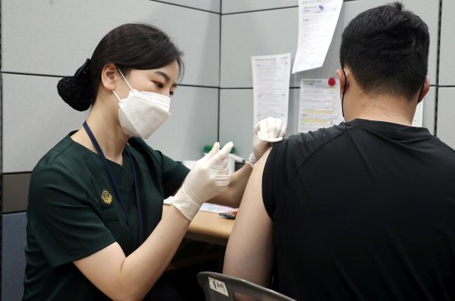 19일 경기도 성남시 국군수도병원 코로나19 예방접종센터에서 국군통신사령부 장병이 화이자 백신으로 2차 접종을 받고 있다. 이경원 기자