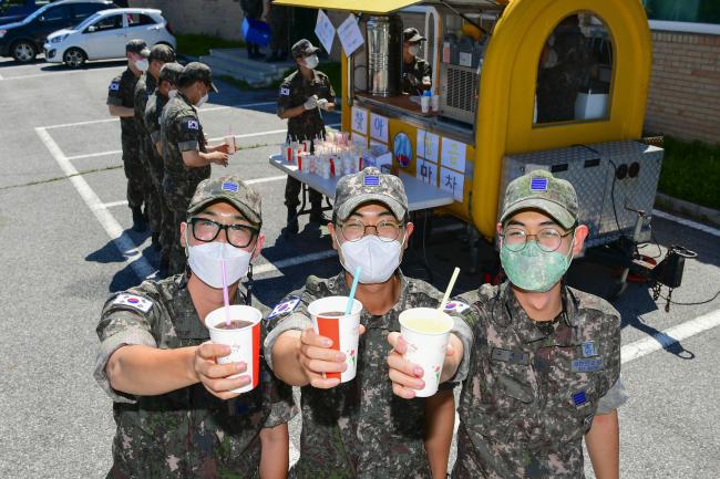 공군20전투비행단 장병들이 22일 찾아가는 황금마차 앞에서 음료를 들어 보이고 있다.  사진 제공=서복남 원사