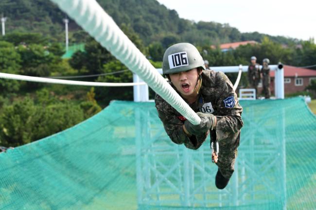 하계 기본군사훈련에 참가한 공군 학군사관 후보생이 지난 23일 유격훈련 중 외줄타기를 하고 있다. 국방부는 폭염 시 마스크 착용으로 인한 온열질환을 예방하기 위해 변경된 실외 마스크 착용 지침을 지난 22일 각 군에 하달했다. 지침에는 “실외에서 다른 사람과 2m 이상 거리 유지가 가능할 경우 마크스를 착용하지 않아도 된다”는 내용이 담겼다. 부대 제공