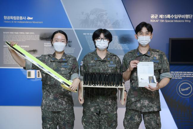 공군15특수임무비행단 김성은(가운데) 하사가 보급업무 개선 아이디어 경연대회에 공모한 아이디어 물품을 들고 동료들과 사진을 찍고 있다. 
 사진 제공=김샛별 중사