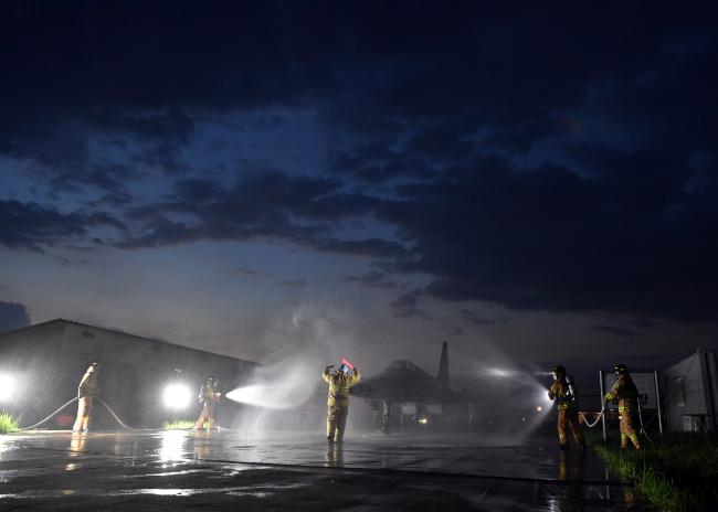 공군38전투비행전대 소방구조반 요원들이 27일 야간 항공기 화재 상황을 가정한 훈련에서 F-5 전투기에 물을 뿌리고 있다.  사진 제공=유영임 상사