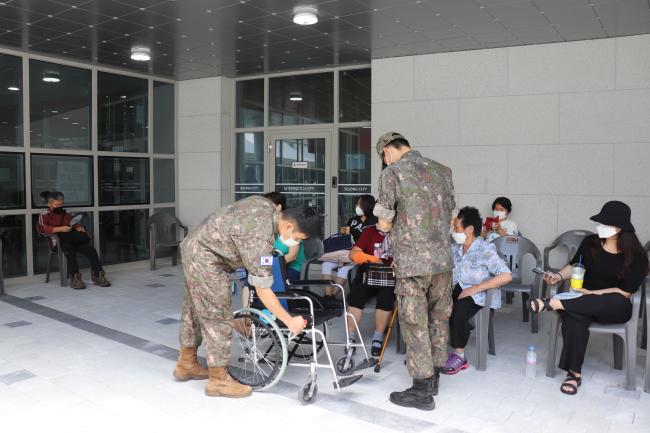 예방접종센터에서 거동이 불편한 시민에게 제공할 휠체어를 살펴보고 있는 32사단 장병들.