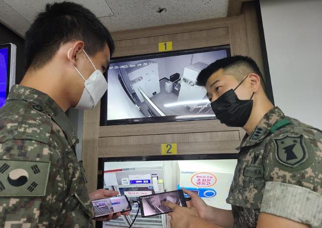 32사단 박상천(오른쪽) 대위와 감시병이 스마트폰 앱과 연동한 24시간 원격 감시체계로 백신 저장시설을 살펴보고 있다.
