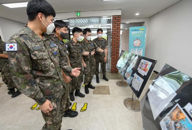 공군1전투비행단이 28일부터 30일까지 병사 그림 그리기 대회 수상작을 전시 중인 가운데 부대원들이 이들 작품을 감상하고 있다.  사진 제공=고미숙 중사