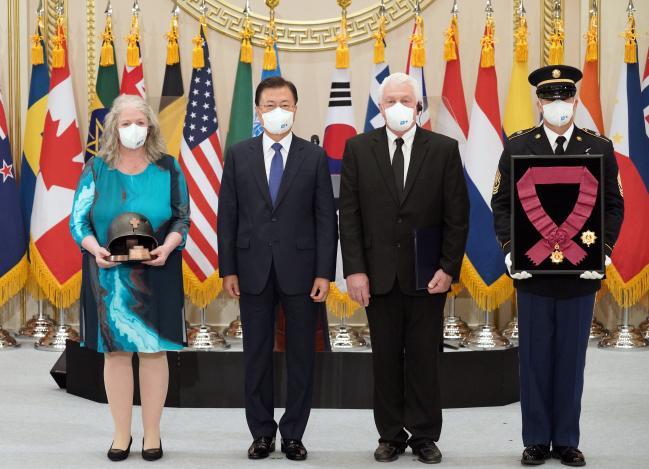 문재인(왼쪽 둘째) 대통령이 지난 27일 오전 청와대 영빈관에서 열린 ‘유엔군 참전의 날 기념 유엔군 참전용사 훈장 수여식’에서 고(故) ○○ ○○○ ○○ 신부의 유족에게 태극무공훈장을 수여한 뒤 기념사진을 찍고 있다.  청와대 제공