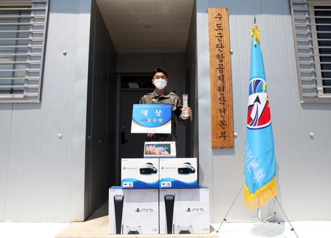 공군항공작전지원단 오우빈 일병이 자기개발 수기 공모전에서 받은 대상 상패와 상품을 들고 기념사진 찍고 있다.  부대 제공