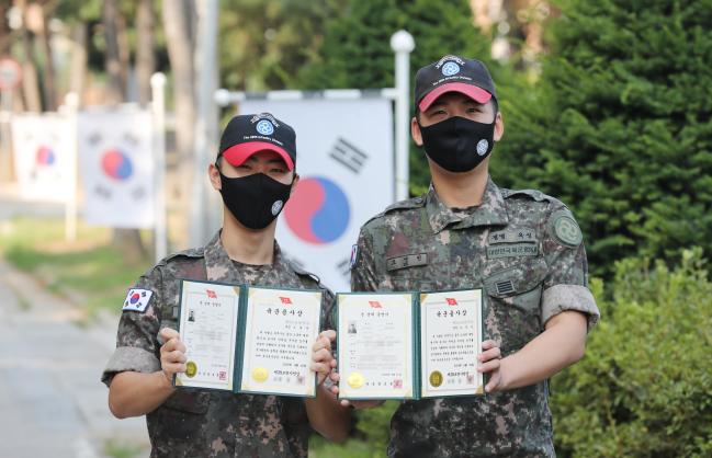 육군28보병사단 돌풍여단 신병교육대대 조교 조원탁(왼쪽)·오영빈 병장이 전역을 앞두고 받은 ‘군 경력증명서’와 ‘육군용사상’을 들어 보이며 활짝 웃고 있다. 육군은 8월 1일부로 병 복무기록 관리체계를 혁신하고, 전역증을 개선한 ‘군 경력증명서’ 발급을 개시했다.  양동욱 기자