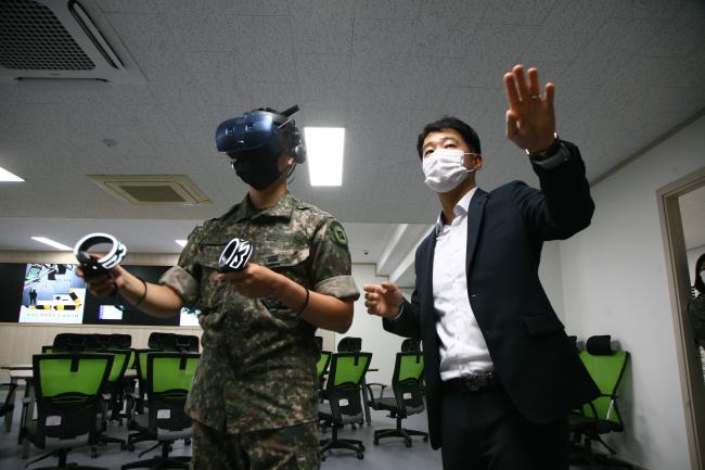 육군정보통신학교 김우중(오른쪽) 교관이 가상현실(VR) 장비를 착용한 류채운 일병에게 대용량전송장비(HCTR) 안테나 장비 설치 VR 실습 방법을 지도하고 있다.  부대 제공