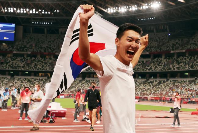 지난 1일 2020 도쿄올림픽 남자 높이뛰기 종목에서 2m 35㎝를 넘어 한국신기록을 세우며 4위를 차지한 ○○○ 육군일병이 도쿄 올림픽스타디움에서 경기 종료 후 태극기를 펼치며 기뻐하고 있다.  연합뉴스