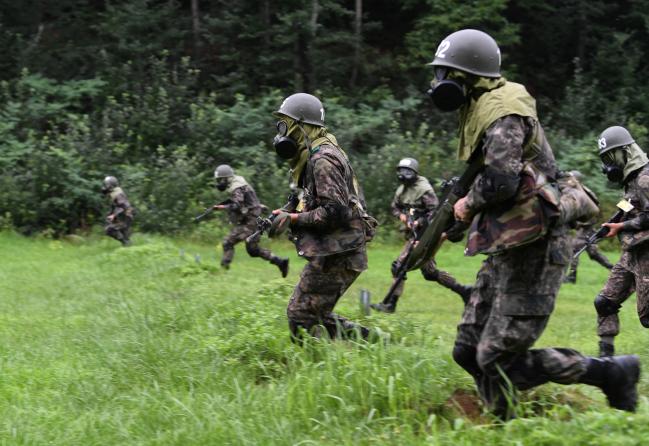 2019년 7월 31일 육군36사단 백호신병교육대대 훈련장에서 19-7기 훈련병들이 신병교육의 ‘하이라이트’로 불리는 ‘병 기본 종합숙달 훈련’ 중 ‘적 포탄 낙하 상황’이 부여되자 방독면을 착용한 가운데 약진하고 있다. 국방일보 조용학 기자
