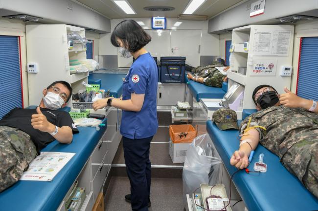 사랑의 헌혈 운동에 동참한 공군1전투비행단 장병들이  헌혈을 하며 엄지손가락을 치켜세우고 있다.  사진 제공=고미숙 상사