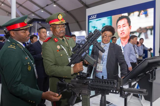 서울 ADEX 2019 전시회에서 앙골라 육군 관계자가 SNT모티브의 신형 소총 STC16을 살펴보고 있다.
