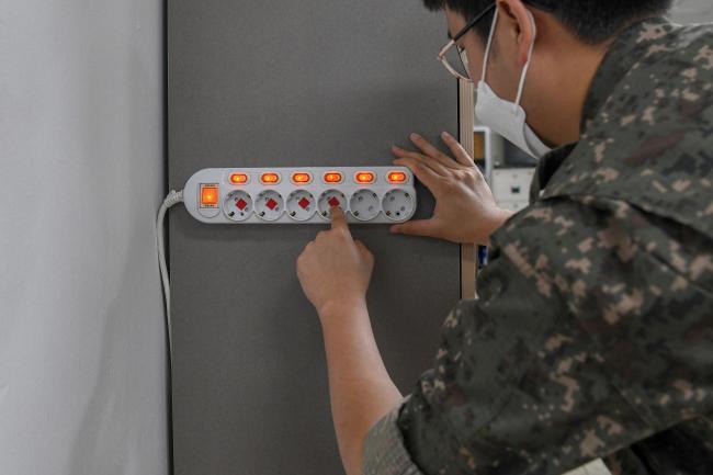 공군3방공유도탄여단이 23일부터 전기 화재 사고 예방 활동을 진행 중인 가운데 군수처 도학진 중사가 사무실 내 멀티탭에 소화 패치를 부착하고 있다.  사진 제공=서동일 하사