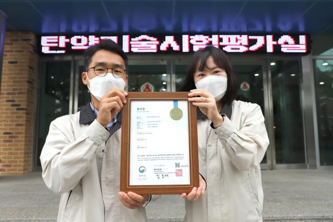 ‘무반동총 탄약의 비군사화 절차 개발’ 발명자인 이인석(왼쪽)·박정미 군무주무관이 특허증을 들고 기념사진을 찍고 있다.  사진 제공=박은설 대위