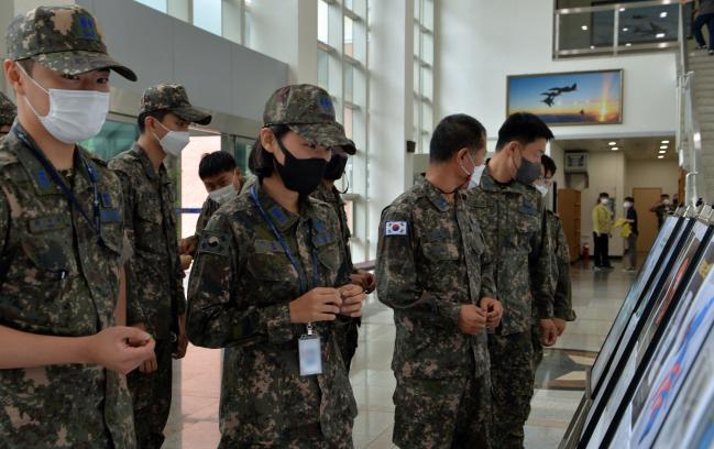 공군11전투비행단 장병들이 지난 23일부터 약 2주간 진행 중인 보안공모전 작품 전시회에서 출품작들을 감상하고 있다.  사진 제공=한윤창 하사
