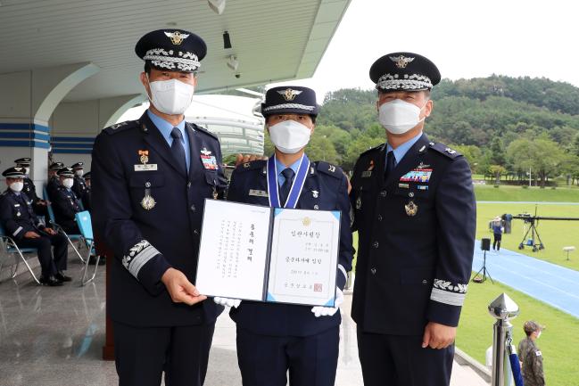 공군교육사령부 박한주(소장·왼쪽) 교육사령관과 김정태(준장·오른쪽) 기본군사훈련단장이 참모총장상을 수상한 강동희 하사에게 계급장을 달아준 뒤 기념사진을 찍고 있다.  부대 제공