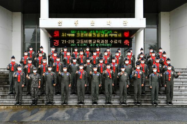 공군1전투비행단이 2일 개최한 21-2차 고등비행교육과정 수료식에서 류진산(앞줄 가운데) 비행단장과 신임 조종사들이 기념사진을 찍고 있다.  부대 제공