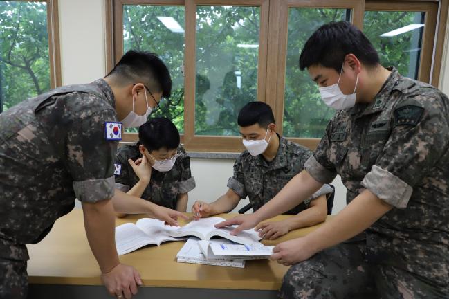 육군대학에서 공부하고 있는 소령 지휘참모과정 교육생들이 수업이 끝난 뒤 동료들과 토의하며 배운 내용을 복습하고 있다.  