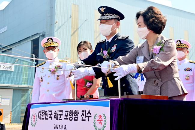 포항함 진수식 주빈인 원인철 합참의장과 부인 이혜명 여사가 샴페인을 선체에 깨뜨리는 안전항해 기원 의식을 진행하고 있다.  해군 제공 