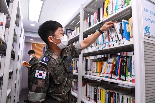공군10전투비행단 장병들이 기지 도서관에서 책을 고르고 있다.  부대 제공