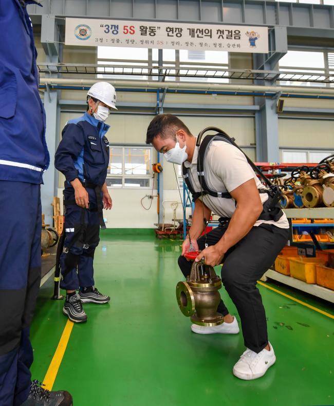 본지 노성수 기자가 허리 보조기기 ‘지게’를 착용하고 소화 밸브를 들어 올리고 있다.