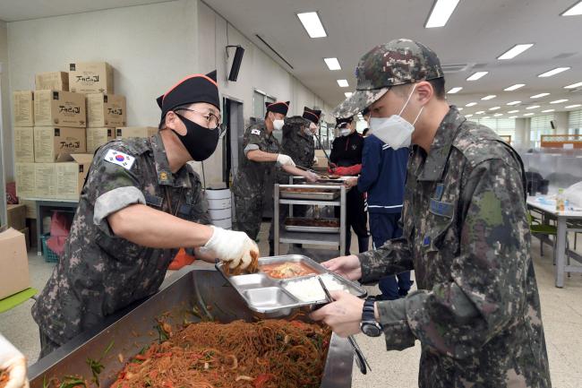 공군17전투비행단 준사관들이 13일 진행된 급식지원 활동에서 장병들에게 음식을 배식하고 있다. 
 사진 제공=이태희 중사