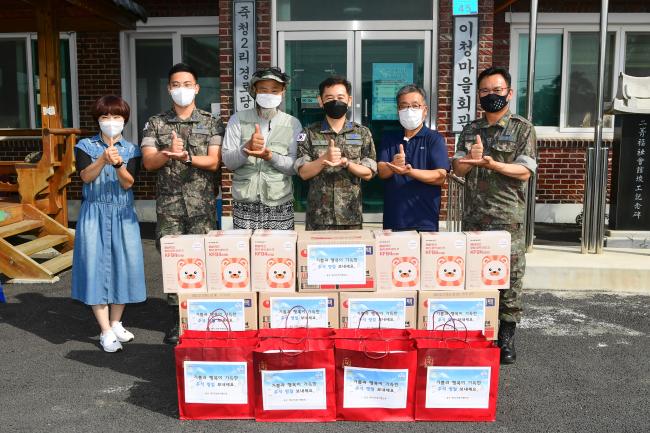 공군20전투비행단 장병들이 13일 부대 인근 마을을 방문해 위문품을 전달한 뒤 주민들과 기념사진을 찍고 있다.  사진 제공=서복남 원사