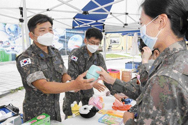 공군20전투비행단 장병들이 14일 진행된 플리마켓 행사에 참여해 판매용 물품을 살펴보고 있다. 

 사진 제공=성재영 일병