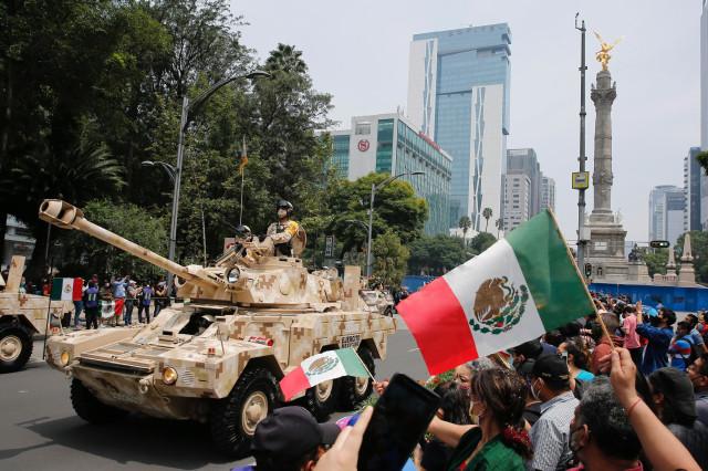 16일 독립기념일을 맞아 멕시코 시민들이 육군의 전차를 비롯한 각종 장비들의 퍼레이드를 보며 환호와 함께 국기를 흔들고 있다. EPA=연합뉴스