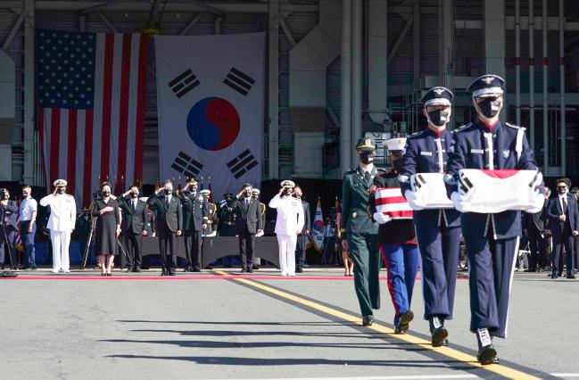 문재인 대통령이 22일(현지 시간) 미국 하와이 히캄 공군기지 19번 격납고에서 열린 한미 유해 상호 인수식에서 공군 1호기로 봉송되는 유해를 향해 경례하고 있다. 대한민국 대통령이 6·25전쟁 전사자 유해 인수식을 해외에서 직접 주관한 것은 이번이 처음이다. 연합뉴스