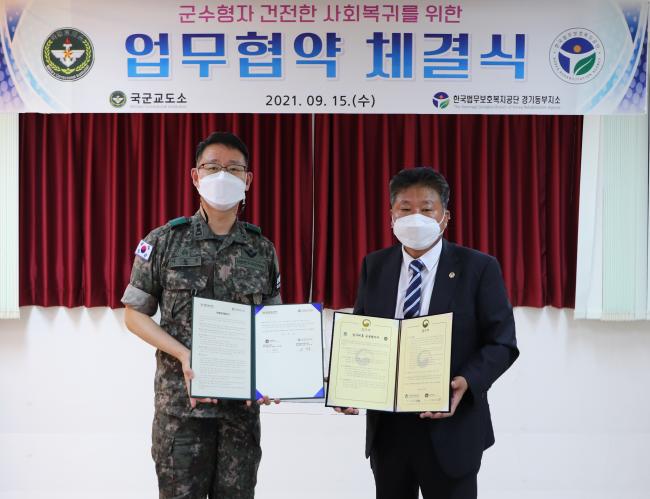 이용훈(왼쪽·육군중령) 국군교도소장과 권영호 한국법무보호복지공단 경기동부지소장이 업무협약을 체결한 뒤 기념촬영을 하고 있다. 부대 제공
