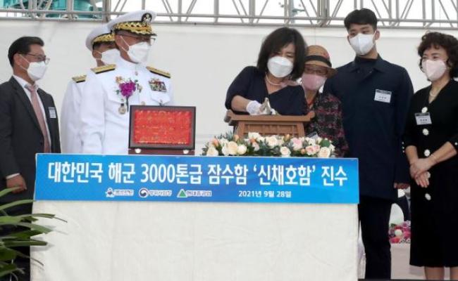 28일 울산 현대중공업에서 열린 3000톤급 잠수함 3번함 신채호함 진수식에서 주빈인 부석종 해군참모총장의 부인 백미자(오른쪽 넷째) 여사가 손도끼로 함정과 연결된 진수줄을 절단하고 있다.  조종원 기자